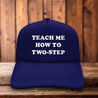 A two-toned polyester trucker hat featuring vintage western-style typography.
