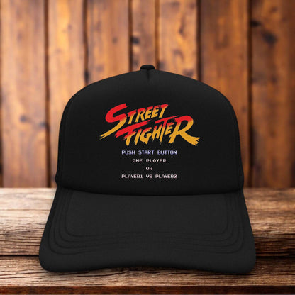 Retro trucker hat with a structured foam front featuring the classic 1987 Street Fighter arcade logo and vintage fighting game graphics.