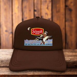An all-brown retro trucker hat featuring the 1970s Schmidt Beer logo with a scenic flying duck illustration on a structured foam front.