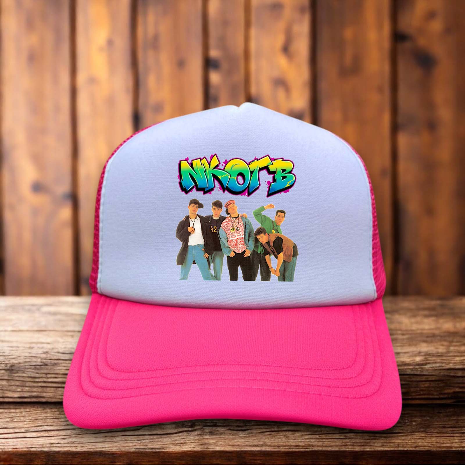 A vibrant neon pink trucker hat with a structured foam front featuring the classic New Kids On The Block logo in black and white.