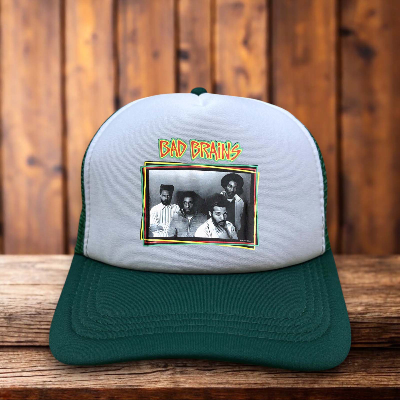 A dark green trucker hat featuring the iconic Bad Brains lightning bolt and Capitol building logo in yellow and black on a structured foam front.