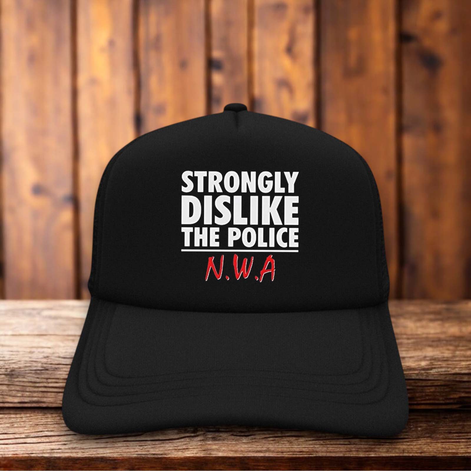 A black and white trucker hat featuring bold, white block lettering on a black foam front that reads "Strong Dislike The Police" in a style reminiscent of the 1980s N.W.A. logo.