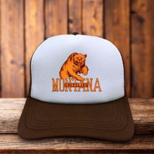 A two-toned polyester trucker hat featuring a vintage Montana Grizzlies football logo.