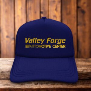 A navy blue foam trucker hat with a vintage Valley Forge Automotive Center logo