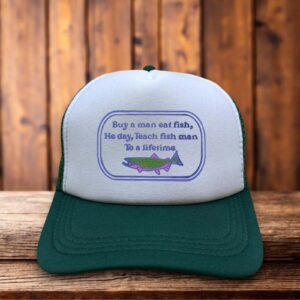 A retro trucker hat featuring the hilariously misquoted "Buy a man eat fish, he day" text in simple, bold typography on a structured foam front.