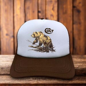 A retro brown trucker hat featuring the rare 1980s Colt Firearms "Bear" logo in white and gold on a structured foam front.